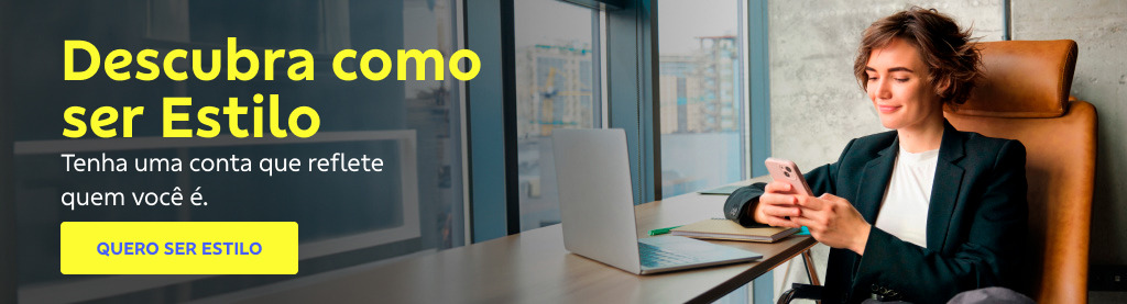Mulher sorri sentada em uma cadeira de escritório, usando um celular, com um notebook aberto à sua frente em uma mesa. Ao lado, texto: Descubra como ser Estilo. Tenha uma conta que reflete quem você é. 
Botão amarelo com a frase: em azul: QUERO SER ESTILO